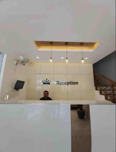 a man in a room with a sign that reads reception at kingdom in Itʼkhvisi