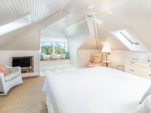 a white bedroom with a bed and a fireplace at Ocean Oasis in Tybee Island