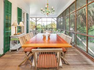a dining room with a wooden table and chairs at Ocean Oasis in Tybee Island