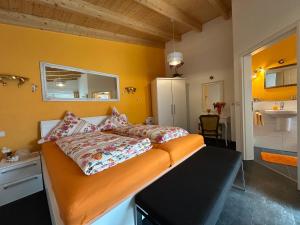 a bedroom with a bed with orange walls at Gästehaus Jupp und Kerstin Korz GbR in Hackenheim