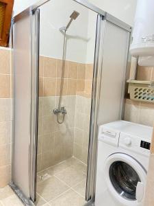 a shower in a bathroom with a washing machine at Arya nature çiftlik in Marmaris