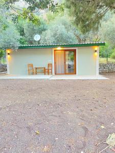 a small white house with a table and chairs at Arya nature çiftlik in Marmaris