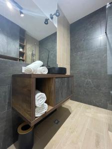 a bathroom with a sink and a shower with towels at Apartament Central Arad AFI 2 camere Ared in Arad