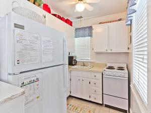 a kitchen with a white refrigerator and a sink at Little House in Tybee Island