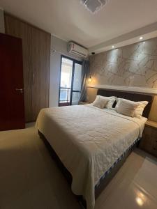 Un dormitorio con una cama grande con sábanas blancas. en Apto 2 quartos com garagem, en Belém 31 fotos más
