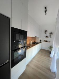 a kitchen with a black and white appliance in it at Apartament Central Arad AFI 2 camere Ared in Arad