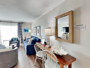 a living room with a blue couch and a mirror at Lighthouse Point 9C in Tybee Island