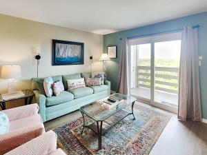 a living room with a couch and a glass table at Lighthouse Point 14B in Tybee Island