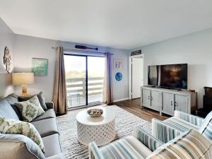 a living room with a couch and a tv at Lighthouse Point 20A in Tybee Island