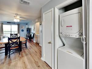 a kitchen and dining room with a refrigerator and a table at Lighthouse Point 20A in Tybee Island