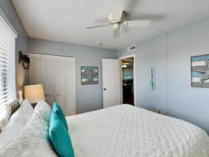 a bedroom with a white bed and a ceiling fan at Lighthouse Point 20A in Tybee Island