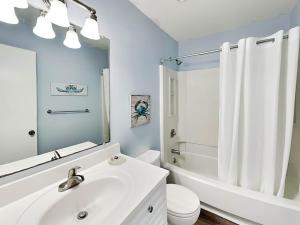 a white bathroom with a sink and a toilet at Lighthouse Point 20A in Tybee Island