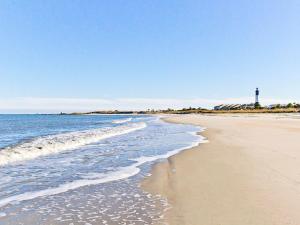 a sandy beach with a lighthouse in the distance at Lighthouse Point 20A in Tybee Island