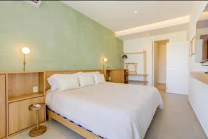 a bedroom with a large white bed and a kitchen at Apartamento Luxury Nayarit vista al mar Mexico in Nuevo Vallarta 