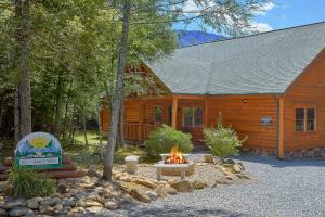 eine Blockhütte mit einer Feuerstelle davor in der Unterkunft Live, Laugh, Love Pool Lodge in Cosby