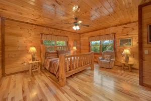 ein Schlafzimmer in einer Blockhütte mit einem Bett und einem Stuhl in der Unterkunft Live, Laugh, Love Pool Lodge in Cosby + 56 Fotos