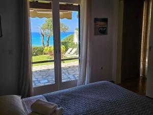 a bedroom with a bed and a view of the ocean at Corfu Glyfada Beach Apartment 49 in Corfu