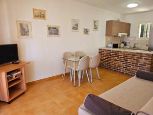 a living room with a table and chairs and a kitchen at Corfu Glyfada Beach Apartment 49 in Corfu