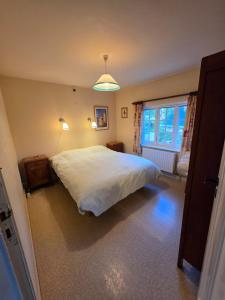 a bedroom with a large white bed and a window at Villa Parrain in Koksijde +16 photos