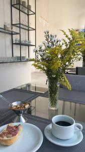 a table with a plate of food and a cup of coffee at Hotel Maria Araújo in Arapiraca