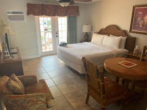 a bedroom with a bed and a table and a chair at Beso Del Sol Resort in Dunedin +31 photos