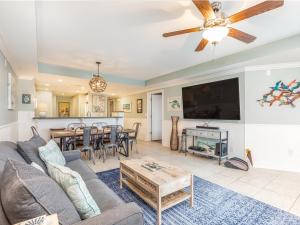 a living room with a couch and a tv and a table at Gull Reef 633 in Tybee Island