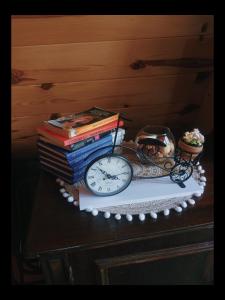 a stack of books and a clock on a table at Squirrel's House in Žabljak