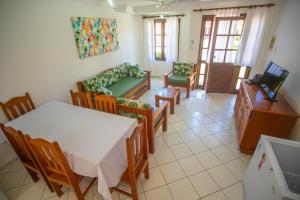 a living room with a table and chairs and a television at Casa Residencial Jerusalém II in Santa Cruz Cabrália +17 photos