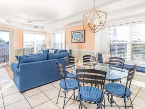 a living room with a blue couch and a glass table at Gull Reef 626 in Tybee Island