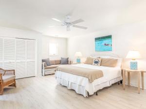 a white bedroom with a large bed and a couch at High Tide in Tybee Island +60 photos