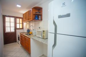 a kitchen with a refrigerator and a microwave at Casa Residencial Jerusalém II in Santa Cruz Cabrália