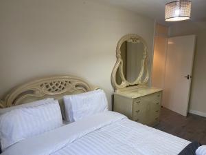 une chambre avec un lit blanc et un miroir dans l'établissement 2 Bed Flat close to New Cross Gate, SE14, à Londres