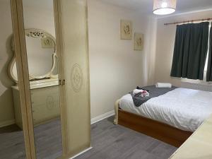 une petite chambre avec un lit et un miroir dans l'établissement 2 Bed Flat close to New Cross Gate, SE14, à Londres
