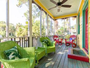een afgeschermde veranda met stoelen en een tafel bij Coastal Soul Cottage in Tybee Island