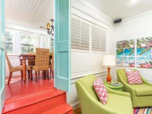 een woonkamer met groene stoelen en een tafel bij Coastal Soul Cottage in Tybee Island