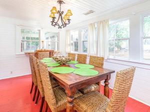 een eetkamer met een houten tafel en stoelen bij Coastal Soul Cottage in Tybee Island +26 foto's