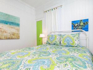 een slaapkamer met een bed met een kleurrijke sprei bij Coastal Soul Cottage in Tybee Island