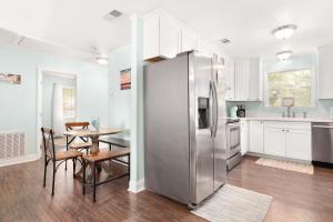 a kitchen with a stainless steel refrigerator and a table at Castaway Cottage in Tybee Island