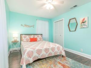 a bedroom with a bed and a ceiling fan at Castaway Cottage in Tybee Island