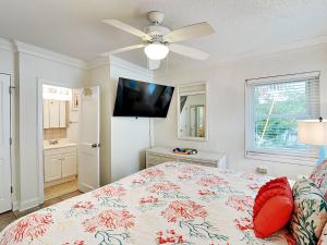 Un dormitorio con una cama y un ventilador de techo. en Captains Quarters B, en Tybee Island
