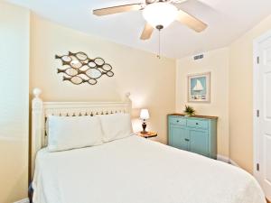 a bedroom with a white bed and a ceiling fan at Captains Watch 11 in Tybee Island +30 photos