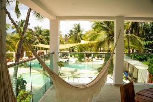 a hammock on the balcony of a resort with a pool at Palmarito Beach Hotel in Tierra Bomba