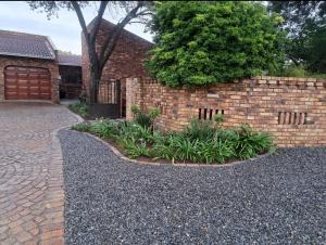 eine gemauerte Stützmauer mit einer gemauerten Auffahrt in der Unterkunft Sweetpea in Boksburg
