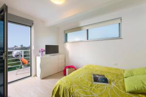 a bedroom with a bed and a window and a balcony at Villa Tammy by Villa Plus in Vodnjan