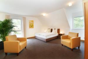 a bedroom with a bed and two chairs at Gästehaus am Schloss in Schwebheim