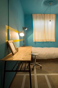 a room with a desk and a bed and a lamp at Apartment Hotel Shinjuku in Tokyo