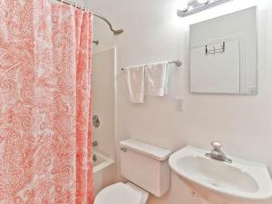 Un baño con un inodoro blanco y un lavabo. en Bikini Top, en Tybee Island 17 fotos más