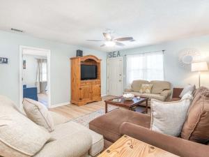 a living room with a couch and a tv at Beach Song in Tybee Island