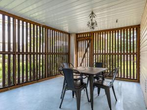 a dining room with a table and chairs and windows at Beach Song in Tybee Island