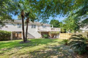 a house with a balcony and a yard at Beach Song in Tybee Island